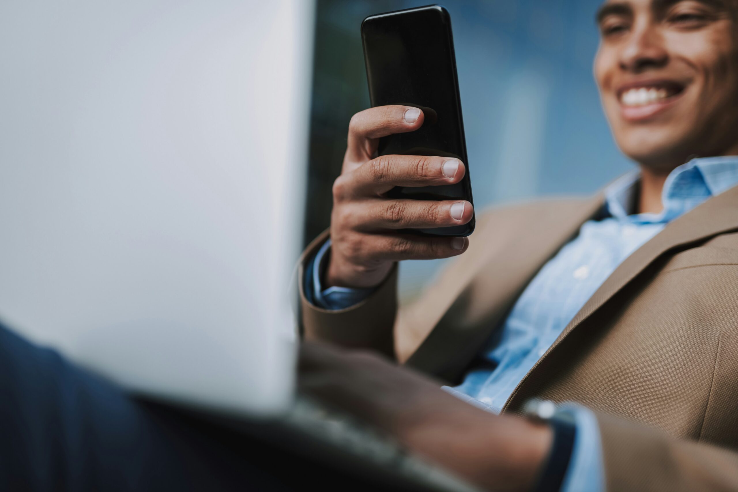 man smiling at phone receiving call from service bdc