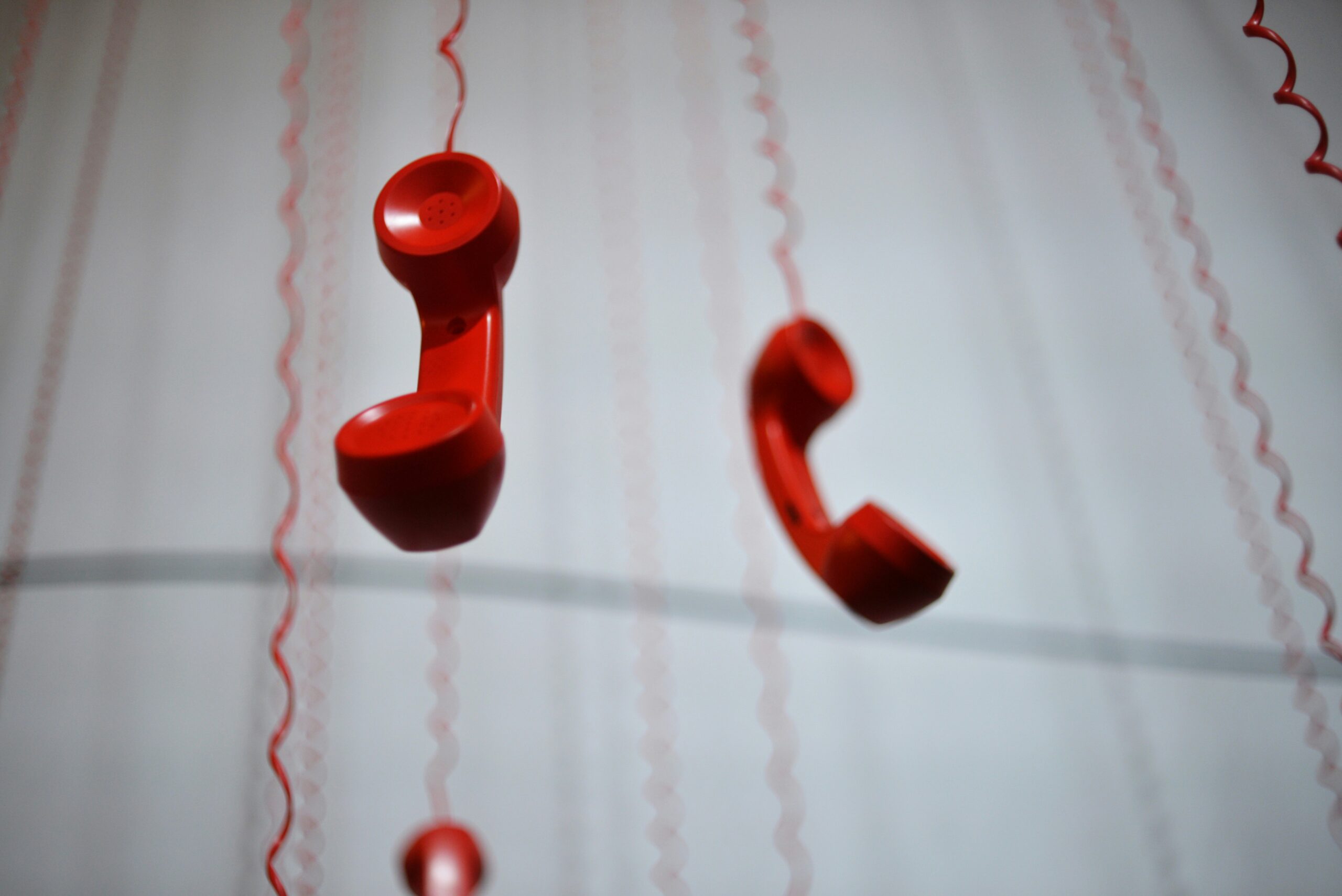 red dial phones hanging from ceiling